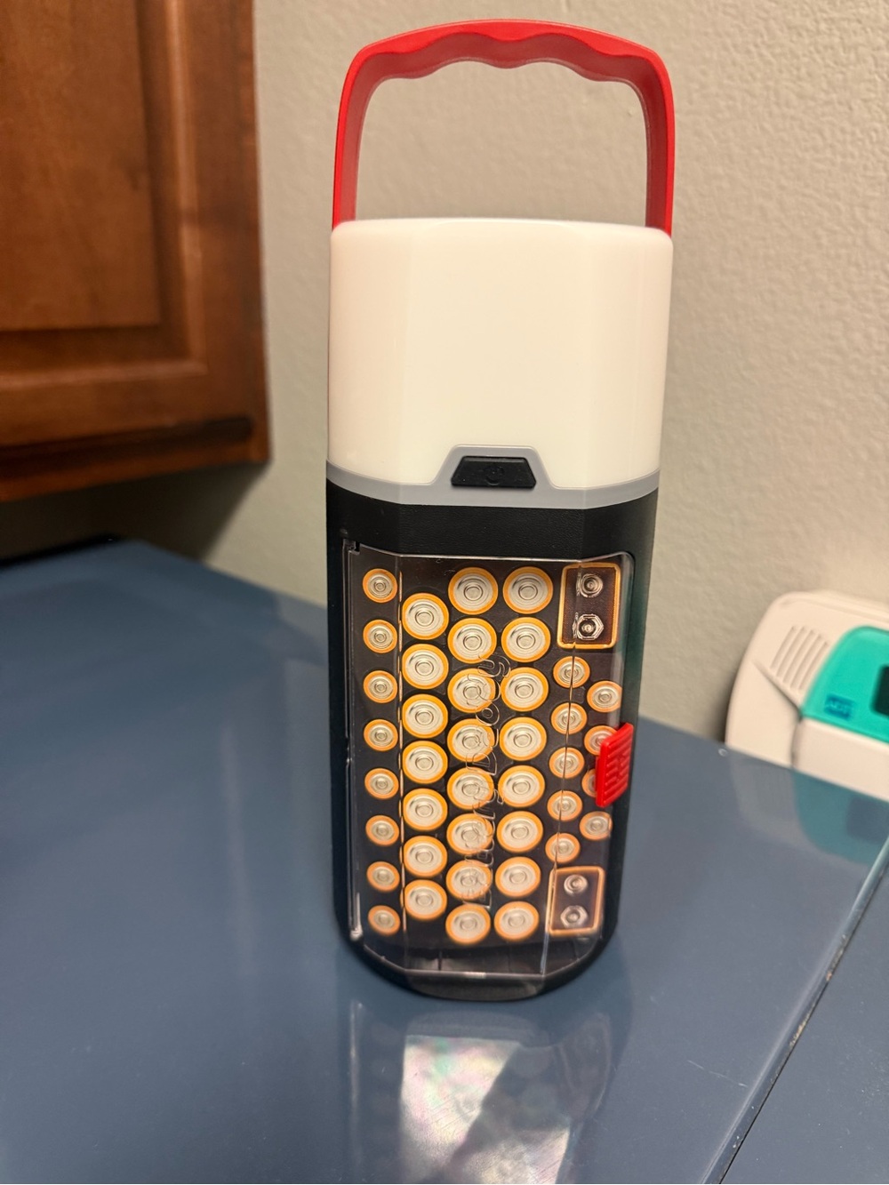Portable White and Black LED Lantern with Red Handle and Battery Storage